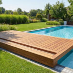 Piscine moderne avec une élégante terrasse coulissante en bois partiellement ouverte, entourée d'un jardin luxuriant et ensoleillé.